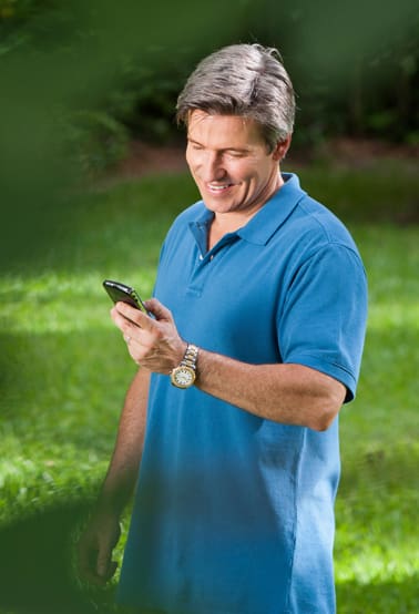 Fling-Irrigation-Inc-man-in-blue-shirt-looking-at-phone